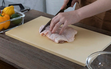 cutting chicken on a cookin cut cutting board by parker asahi