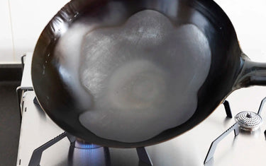 Burning off the anti-rust coating on a new wok
